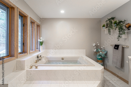 фотографія Modern spa bathroom with built-in soaking tub, marble tile surround and large wi