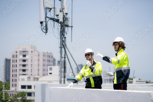 Wallpaper Mural Professional telecommunication technician team talking walkie-talkie radio command rooftop cell tower, engineer worker inspecting transmitter signal network system wireless technology service. Torontodigital.ca