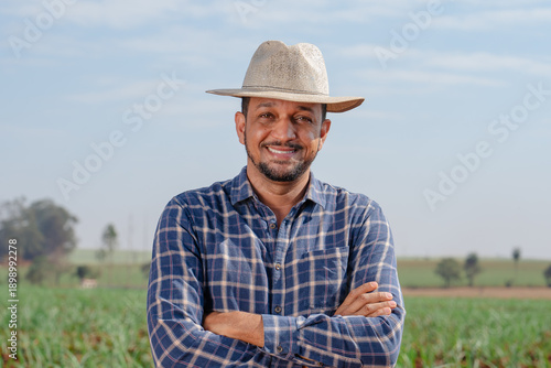 Valokuva Portrait of a confident male farmer in a straw hat and plaid shirt standing with
