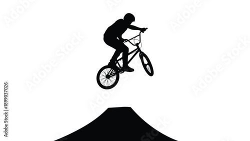 Silhouette of a bmx freestyle rider performing an impressive jump trick off a ramp against a stark white background