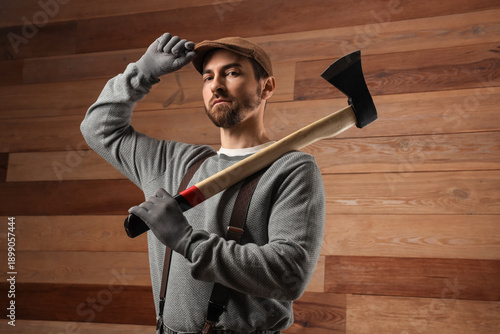 Man with ax on wooden backg...
