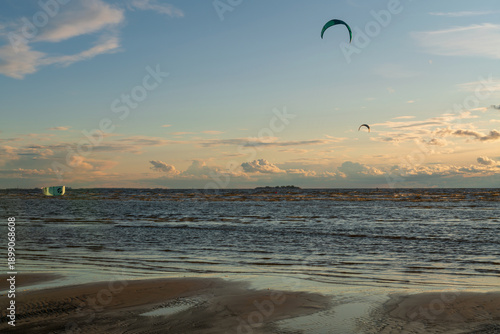Sandy beach on the Baltic Sea coast and kitesurfing kites in the sky on a sunny summer day, Sestroretsk, Kurortny District, Saint Petersburg, Russia