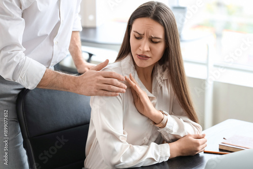 Quadro su tela Businessman molesting his female colleague at desk in office
