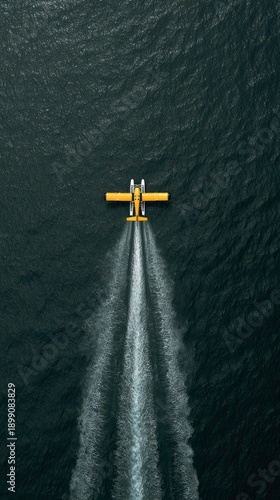 Yellow seaplane flying over dark water