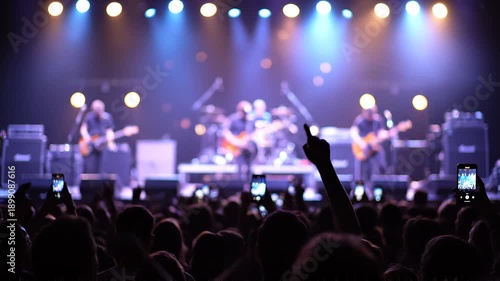 Wallpaper Mural  Silhouette of concert audience with raised hands, blurred stage in background, glowing light Torontodigital.ca