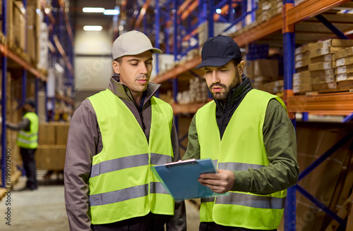Foto Workers in warehouse review inventory on clipboard