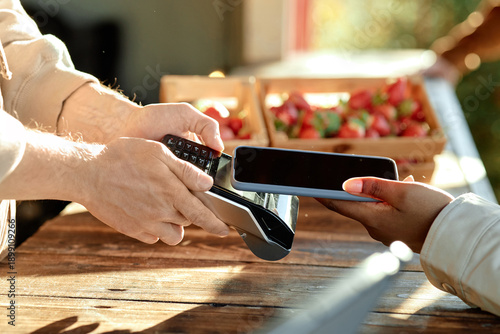 Foto Caucasian man holding payment terminal while young Black woman making contactles