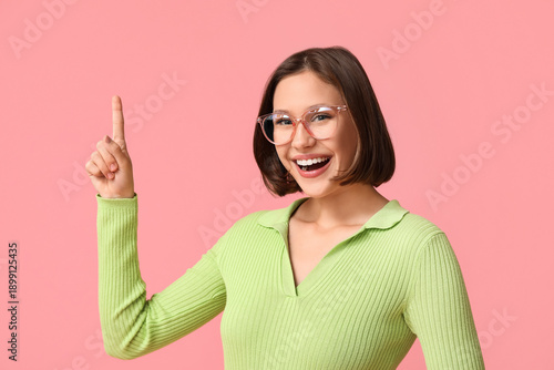 Happy young woman pointing ...