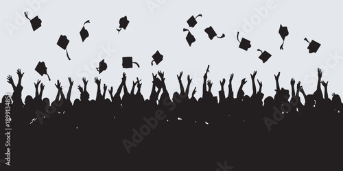 Silhouette of a crowd of people celebrating graduation by throwing their caps in the air.