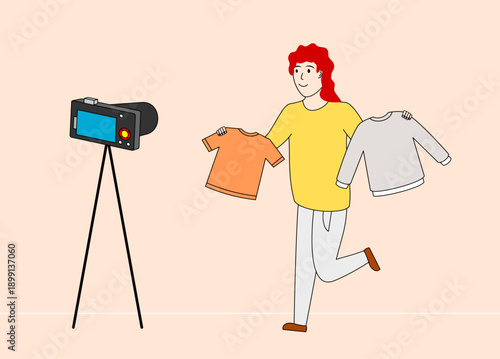 Woman is holding up a shirt and a t-shirt in front of a camera