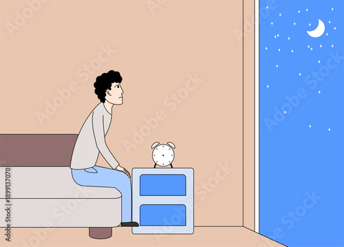 Man is sitting on a bed on a nightstand. The man is looking out the window at the night sky