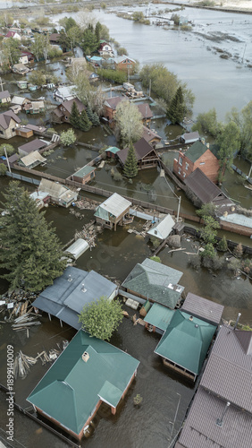 Aerial drone footage of a massive city flood with houses and streets submerged under water. Urban flooding caused by extreme weather and heavy rainfall, showing natural disaster impact on residential 