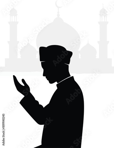 Silhouette of a man praying in front of a mosque.