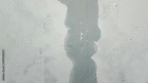 Water flowing from above onto the wall due to a leak in the roof. Home maintenance and renovation concepts