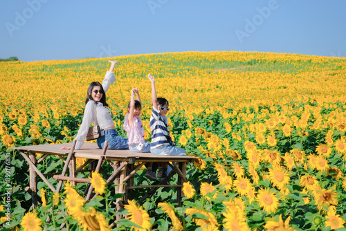 Happy mother and children in sunflower field, family love, summer nature in Khaoyai, Thailand