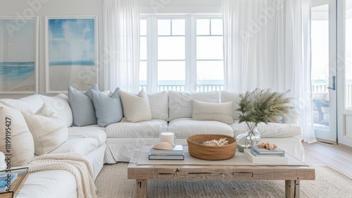 Serene beach-inspired living room featuring a large white sectional sofa, coastal accent pillows, a weathered wood coffee table, and framed ocean art, creating a relaxed ambiance.
