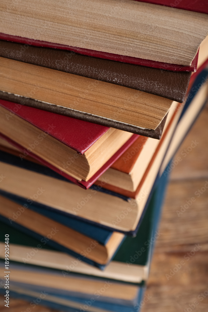 Fototapeta premium Stack of old hardcover books on wooden background, closeup