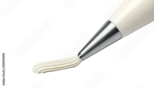 Pastry bag piping smooth, white frosting onto a surface, isolated on a black background