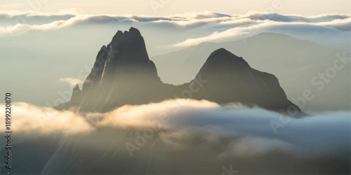 A breathtaking panorama of misty clouds drifting over snow-capped mountains at sunset, where the golden light of the horizon illuminates a serene winter landscape of forest valleys and peaks