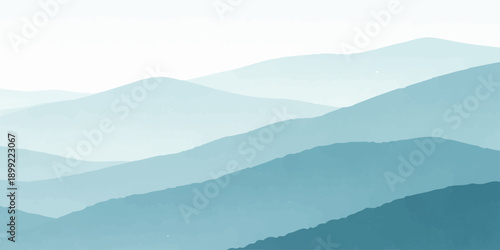 A serene morning mist blankets the blue mountain range as clouds drift over a silhouette of forest hills at sunrise, creating a breathtaking nature landscape view of the valley at dawn