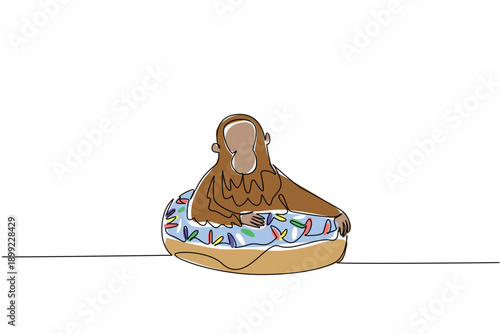 Single line drawing of playful cute animal shows an orange orangutan lying inside glazed donut for pastry food concept. Colorful art is perfect for nursery poster purpose with an adorable forest ape