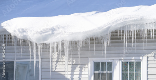 winter house with icicle and snow on the roof