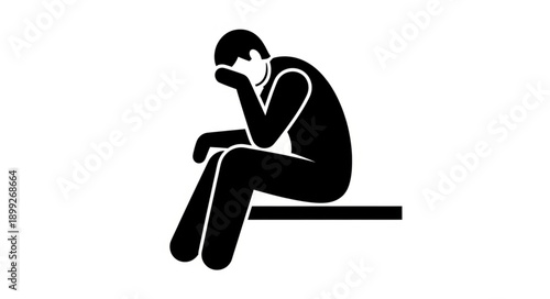 Silhouette of a person sitting with head in hands.