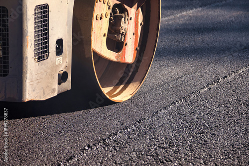 Fotografia A heavy asphalt roller compacts freshly laid asphalt on a newly constructed road