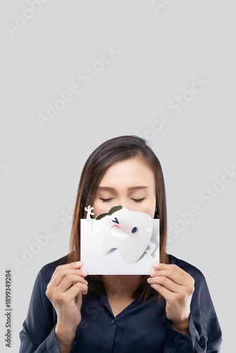 A woman holds a friendly cartoon tooth to gently communicate decay, cracks, and sensitivity, reflecting premium dental care with a calm and reassuring approach. 