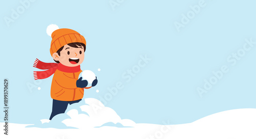 Energetic young boy wearing an orange winter jacket and hat playing happily in deep snow and holding a perfectly round snowball.