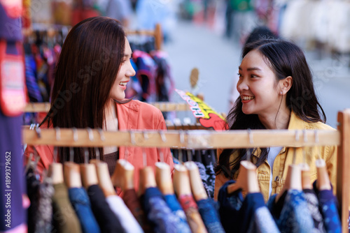 Asian women friends smiling shopping at street market