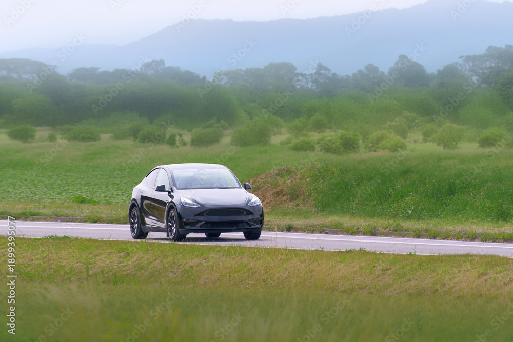 Fototapeta premium Innovative electric car driving in natural environment