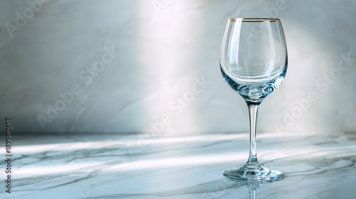 stemware. A crystal-clear wine glass on a marble countertop, reflecting soft light in an elegant minimalist scene. bar promotions.