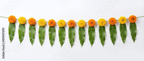 Indian flower garland of mango leaves and marigold flowers. Ugadi diwali ganesha festival poojas weddings functions holiday ornate decoration. Isolated on white background