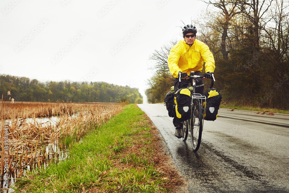 Obraz premium Mature man, cyclist and bicycle in nature for fitness, nomad travel and endurance challenge. Space, male person and cycling for bikepacking, workout safety and gear for minimalist adventure outdoor