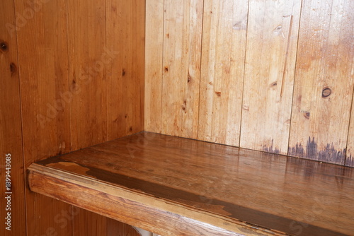 A shelf with a wooden top and a shelf below it. The shelf above is full of wood