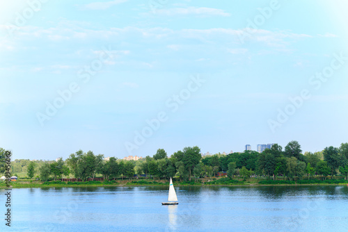 floating boat in river outskirts country side nature view of water and greenery foliage clear weather summer day
