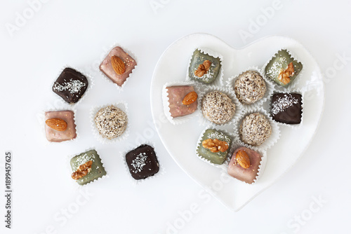 Minimalist flat lay of handmade chocolates with heart-shaped plate.