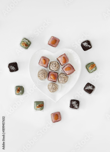 Minimalist flat lay of handmade chocolates with heart-shaped plate.
