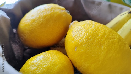 Fresh ripe lemons and yellow bananas in a bowl