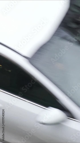 pedestrians crossing a crosswalk on a rainy day with cars that don't stop when they see them , 4k vertical video footage