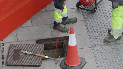 electrician worker install traffic light or optical fiber cables for internet and telephone underground lines in city street , horizontal full hd video footage 