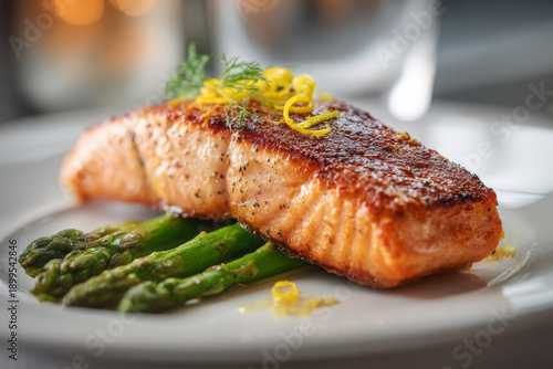 Gourmet pan seared salmon fillet served with crisp asparagus on white plate presents healthy seafood dinner meal, offering satisfying inviting culinary experience for hungry guest