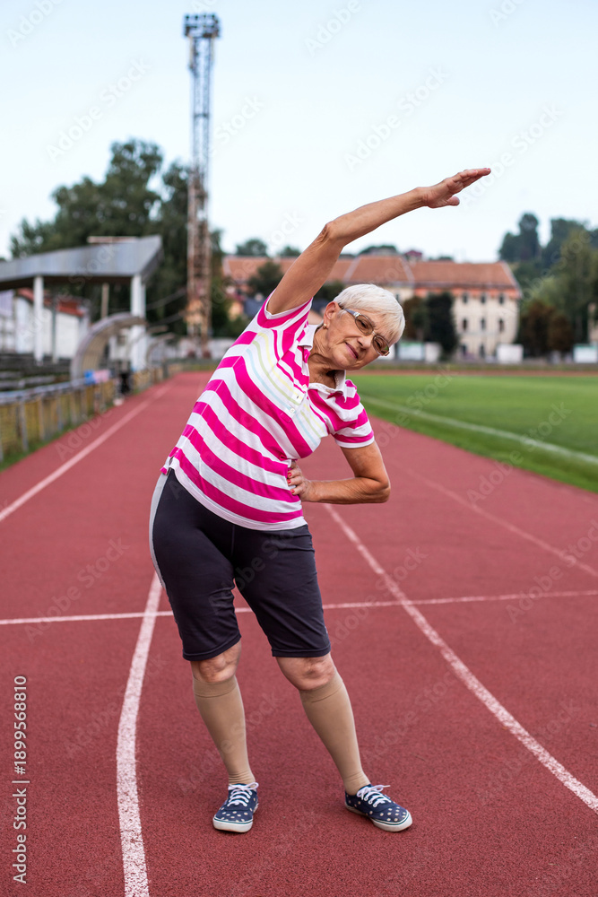 Obraz premium Woman running in the stadium. Sports exercises, warm-up