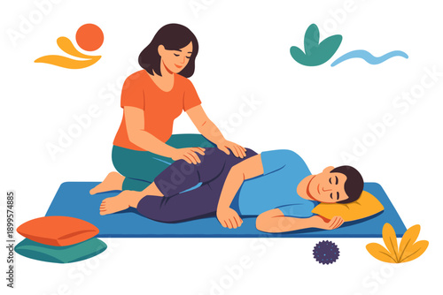 Therapist performing massage on a patient lying on a mat with pillows for comfort