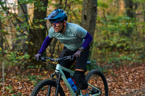 Mountain Biker Races Through Autumn Forest Trail Wearing Helmet and Knee Pads During Outdoor Adventure