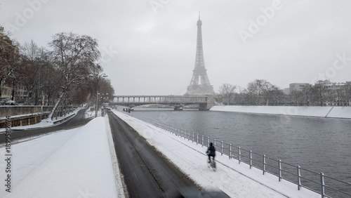 A person is riding a bicycle on the snow in Paris