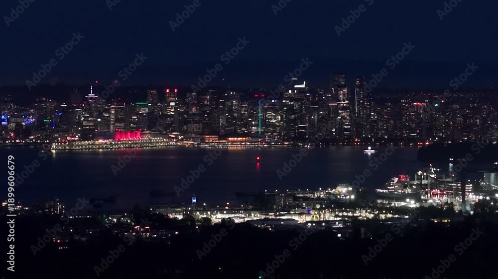 custom made wallpaper toronto digitalNighttime panoramic view of Vancouver’s downtown skyline seen across Vancouver Harbour, featuring illuminated skyscrapers, glowing waterfront lights, and reflections on calm water under a dark sky.