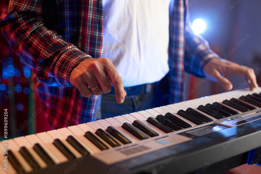 Obraz premium A close-up of hands playing a digital keyboard synthesizer