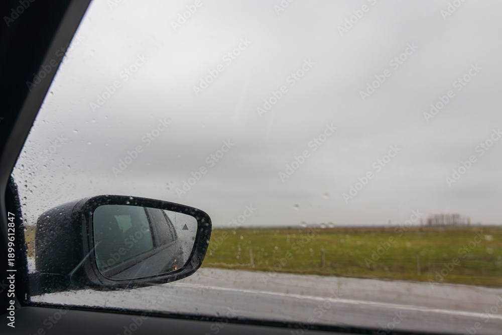 Obraz premium View in the side mirror of a car on road.